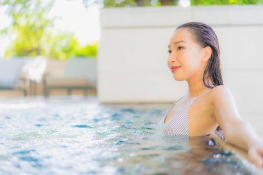 Güzel Asyalı kadın gülümsemesi. Tatil için yüzme havuzunda rahatla.