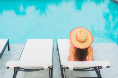 Güzel bir Asyalı kadın portresi. Rahatlayın. Yüzme havuzu etrafında gülümseyin.