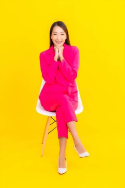 Güzel bir Asyalı kadın sarı arka planda gülümsüyor.