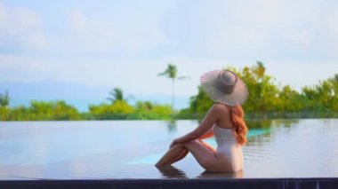 Güzel, genç Asyalı bir kadının dinlenme, dinlenme, deniz kenarında yüzme havuzu, tatil için deniz kenarında yüzme görüntüsü.