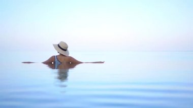 Güzel, genç Asyalı bir kadının dinlenme, dinlenme, deniz kenarında yüzme havuzu, tatil için deniz kenarında yüzme görüntüsü.