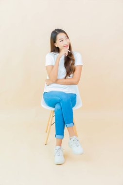 Portre güzel Asyalı kadın gülüşü krem rengi arka planda.