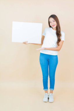 Güzel bir Asyalı kadın portresi. Krem arka planda boş beyaz ilan panosu kağıdı gösteriyor.