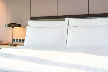 Yatak odasının iç kısımlarında beyaz rahat yastık ve battaniye.