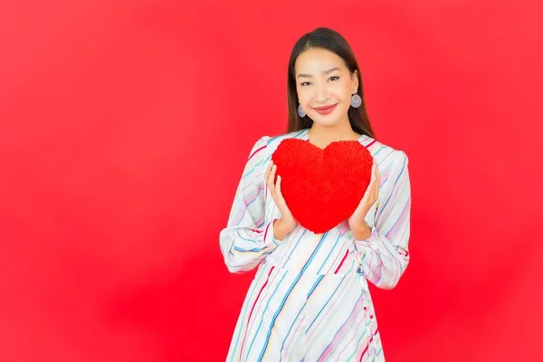 Portret Piękna Młoda Azjatycka Kobieta Kształtem Poduszki Serca Czerwonym Tle — Zdjęcie stockowe