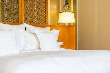 Yatak odasının iç tarafındaki yatak dekorasyonunda rahat beyaz yastık.