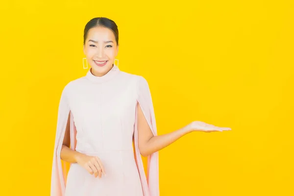 Güzel Asyalı Kadın Gülümsüyor Sarı Arka Planda Birçok Hareket Var — Stok fotoğraf