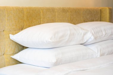 Yatak odasının içinde lamba süslemesi olan beyaz yastık ve battaniye.