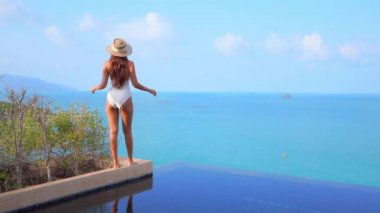 Güzel, genç Asyalı bir kadının dinlenme, dinlenme, deniz kenarında yüzme havuzu, tatil için deniz kenarında yüzme görüntüsü.