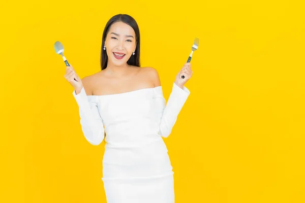 Güzel Genç Kadını Asyalı Bir Kaşık Çatalla Sarı Arka Planda — Stok fotoğraf