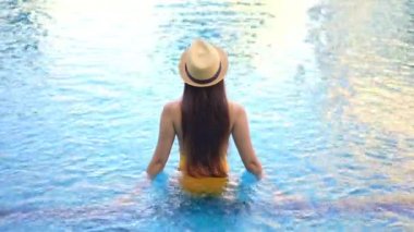 Güzel, genç Asyalı bir kadının dinlenme, dinlenme, deniz kenarında yüzme havuzu, tatil için deniz kenarında yüzme görüntüsü.
