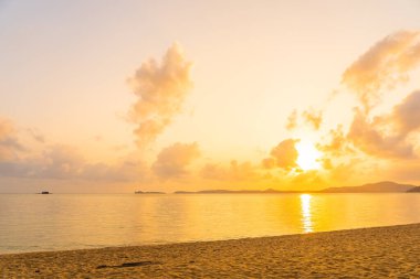 Günbatımında bulutlu ve gökyüzü olan güzel tropikal deniz okyanusu ya da seyahat ve tatil için gün doğumu zamanı