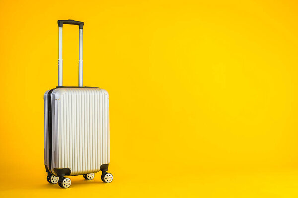 Gray color luggage or baggage bag use for transportation travel and leisure on yellow isolated background