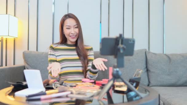 スマートフォンでメイクやブログをしている美しいアジア系女性の映像 — ストック動画
