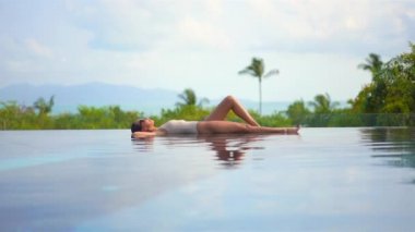 Güzel, genç Asyalı bir kadının dinlenme, dinlenme, deniz kenarında yüzme havuzu, tatil için deniz kenarında yüzme görüntüsü.