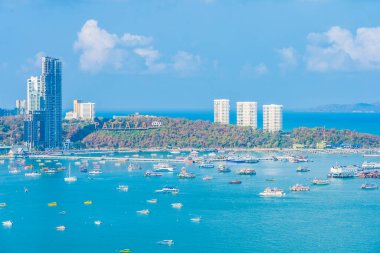 Beyaz bulut mavi gökyüzü ve Tayland 'ın Pattaya şehrindeki mimari yapı çevresindeki güzel tropikal sahil okyanus körfezi.