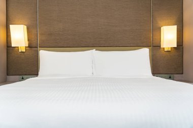 Yatak odasının iç dekorasyonuna beyaz yastık ve battaniye.