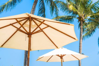 Boş güverte sandalyesi şemsiyesi ile sahil kıyısı okyanus mavi gökyüzü tatil için