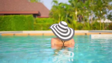 Güzel, genç Asyalı bir kadının dinlenme, dinlenme, deniz kenarında yüzme havuzu, tatil için deniz kenarında yüzme görüntüsü.