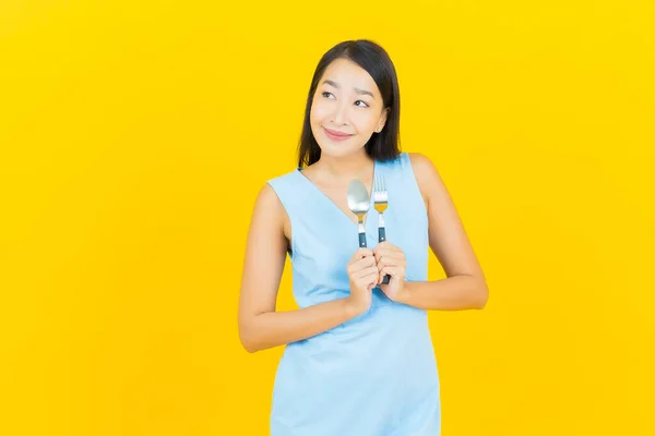 Portret Piękna Młoda Azjatycka Kobieta Uśmiech Łyżeczką Widelcem Żółtym Tle — Zdjęcie stockowe