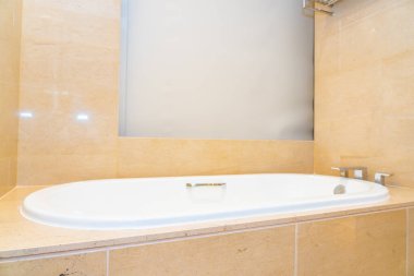 Banyonun içi musluk dekorasyonuyla dolu boş bir banyo küveti.