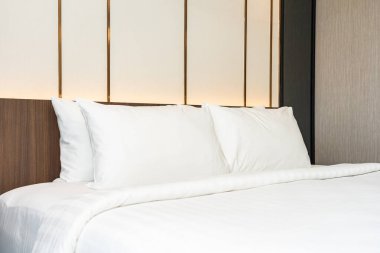 Yatak odasının iç dekorasyonuna beyaz yastık ve battaniye.