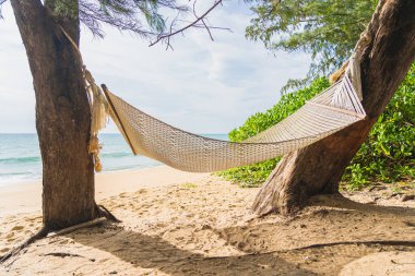 Tropikal deniz okyanusunda boş bir hamak. Tatil seyahatinde rahatla.