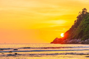 Sahildeki okyanusun etrafındaki dağda güzel bir gün batımı ve doğa gezisi için kaya.