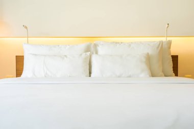 Yatak odasının iç dekorasyonuna beyaz yastık ve battaniye.