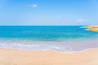 Yolculuk için beyaz bulutlu ve mavi gökyüzü arka planlı güzel tropikal deniz okyanusu