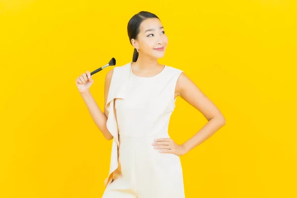 Portrét Krásná Mladá Asijská Žena Make Kartáč Kosmetické Žlutém Pozadí — Stock fotografie