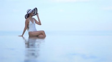 Güzel, genç Asyalı bir kadının dinlenme, dinlenme, deniz kenarında yüzme havuzu, tatil için deniz kenarında yüzme görüntüsü.