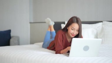 Evde dizüstü bilgisayarla çalışan Asyalı güzel bir kadının görüntüleri.