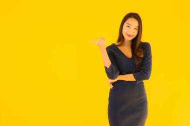 İzole edilmiş sarı arka planda hareketli güzel Asyalı kadın portresi.