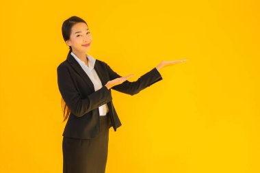 Güzel portre genç iş kadını Asyalı mutlu gülücük sarı izole arka planda birçok eylem