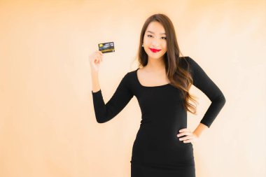 Renkli arka planda alışveriş yapmak için kredi kartı olan güzel bir Asyalı kadın portresi.