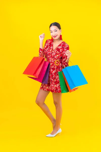 Sarı Arka Planda Renkli Alışveriş Çantalı Güzel Asyalı Kadın Portresi — Stok fotoğraf