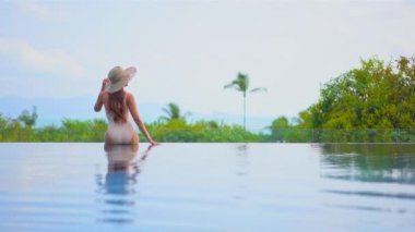 Güzel, genç Asyalı bir kadının dinlenme, dinlenme, deniz kenarında yüzme havuzu, tatil için deniz kenarında yüzme görüntüsü.