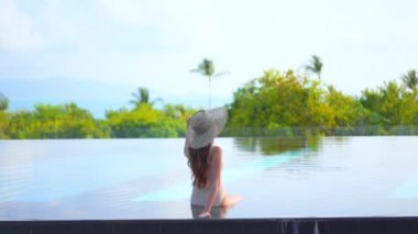 Güzel, genç Asyalı bir kadının dinlenme, dinlenme, deniz kenarında yüzme havuzu, tatil için deniz kenarında yüzme görüntüsü.