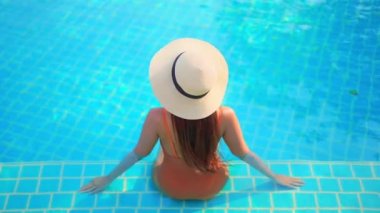 Güzel, genç Asyalı bir kadının dinlenme, dinlenme, deniz kenarında yüzme havuzu, tatil için deniz kenarında yüzme görüntüsü.
