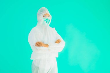 Güzel, genç Asyalı doktor kadın portre. Koronavirüsten ya da mavi arka planda kovid19 'dan korunmak için ppe ya da kişisel koruyucu ekipman takıyor.