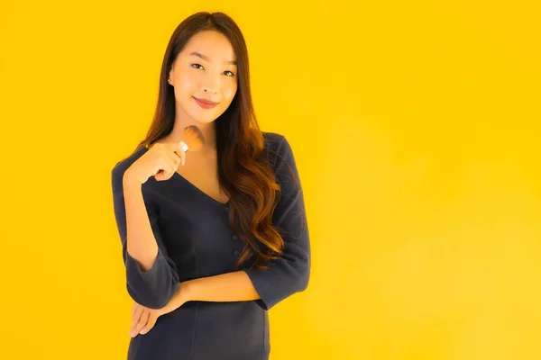 Sarı Izole Arkaplanda Makyaj Fırçası Olan Güzel Bir Asyalı Kadın — Stok fotoğraf