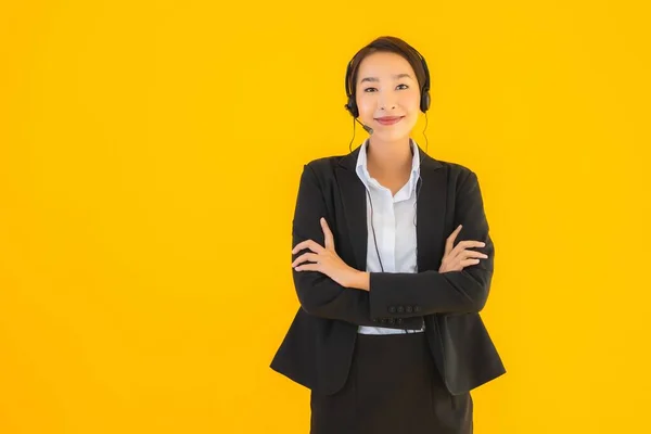 带有耳机或耳机的形象漂亮的年轻亚洲商人妇女 供呼叫中心或在黄色孤立背景下进行电话推销 — 图库照片