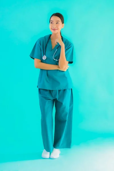 ポートレート美しいです若いですアジアの医師女性笑顔ともに多くのアクション上の青隔離された背景 — ストック写真