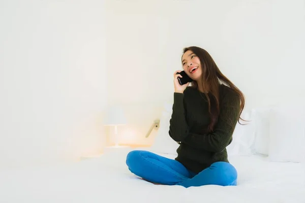 stock image Portrait beautiful young asian woman use smart mobile phone on bed with white pillow blanket in bedroom interior