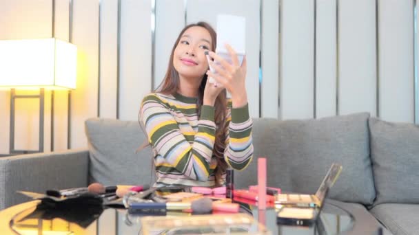 スマートフォンでメイクやブログをしている美しいアジア系女性の映像 — ストック動画