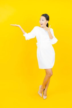 Portre güzel Asyalı kadın gülümsüyor. Renkli arka planda hareket var.