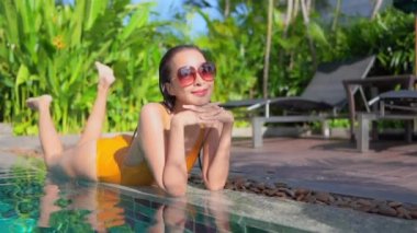 Güzel, genç Asyalı bir kadının dinlenme, dinlenme, deniz kenarında yüzme havuzu, tatil için deniz kenarında yüzme görüntüsü.
