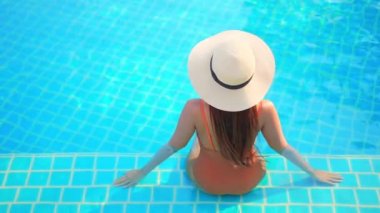 Güzel, genç Asyalı bir kadının dinlenme, dinlenme, deniz kenarında yüzme havuzu, tatil için deniz kenarında yüzme görüntüsü.