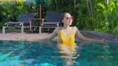 Güzel, genç Asyalı bir kadının dinlenme, dinlenme, deniz kenarında yüzme havuzu, tatil için deniz kenarında yüzme görüntüsü.